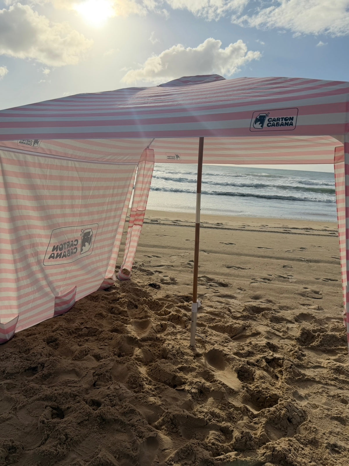 Sorbet Cabana with the detachable side wall attached, low sun over the ocean behind it